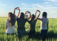 Youth in a rolling field holding hands